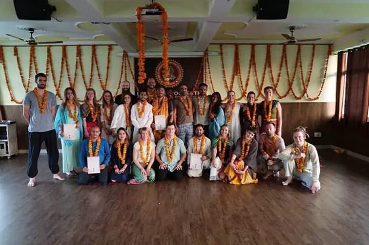 Deep Yoga graduates holding marigold garlands after their yoga teacher training in Rishikesh