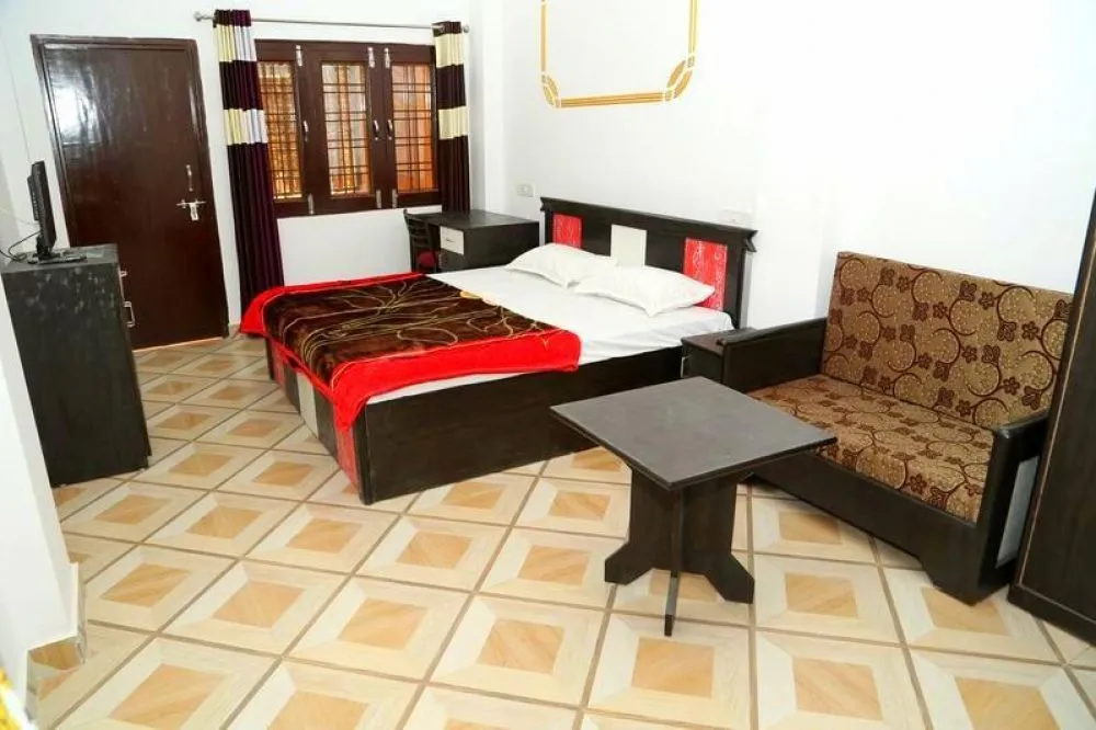 Spacious private room with a double bed, seating and study desk at Deep Yoga, Tapovan